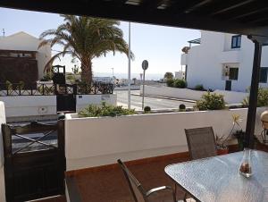 een terras met een tafel en stoelen en een gebouw bij Casa Brisamar in Puerto del Carmen