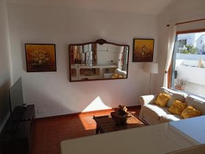 een woonkamer met een bank en een spiegel bij Casa Brisamar in Puerto del Carmen