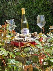 a bottle of wine and two glasses on a table at Location en bordure du Trieux in Plourivo