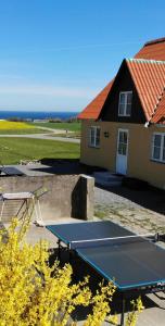 una mesa de ping pong frente a una casa en Solhjem Bornholm - sea view - big garden, en Gudhjem