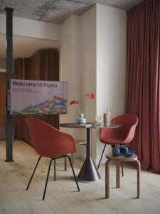 een bord in een kamer met twee stoelen en een tafel bij Numa Rotterdam Coolsingel in Rotterdam
