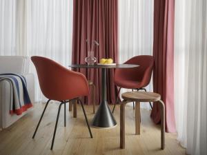 een eetkamer met twee stoelen en een tafel met een fruitschaal erop bij Numa Rotterdam Coolsingel in Rotterdam