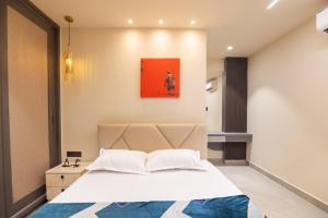 RR Home's, 2BHK-II Near US Consulate, Gachibowli في حيدر أباد: غرفة نوم بها سرير ولوحة على الحائط