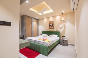 RR Home's, 2BHK-II Near US Consulate, Gachibowli في حيدر أباد: غرفة نوم بسرير اخضر ومكتب