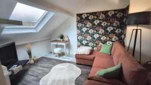 La Girouardière في لا فليش: غرفة معيشة مع أريكة وجدار زهرة