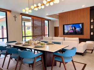 a dining room with a table and blue chairs at Villa Daun Emas in Jimbaran