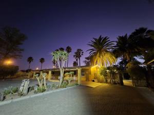 una casa con palmeras delante de ella por la noche en Vogelsang Guesthouse, en Omaruru 65 fotos más