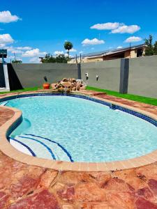 Que Self Catering Apartments - Block7 في غابورون: مسبح كبير في ساحه بها حشرات