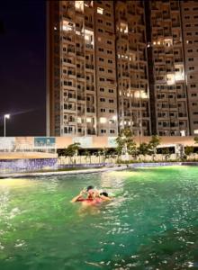 una persona en el agua en una piscina en una ciudad en Aesthetic Modern 2BHK Work & Relax Balcony Views, en Jāmb
