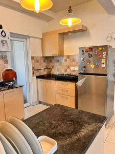 cocina con nevera de acero inoxidable con imanes en Aesthetic Modern 2BHK Work & Relax Balcony Views, en Jāmb