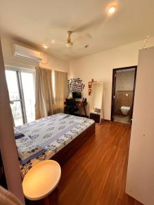 Un dormitorio con una cama y un escritorio. en Aesthetic Modern 2BHK Work & Relax Balcony Views, en Jāmb