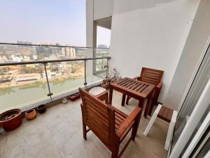 balcón con 2 bancos, mesa y ventana en Aesthetic Modern 2BHK Work & Relax Balcony Views, en Jāmb 31 fotos más