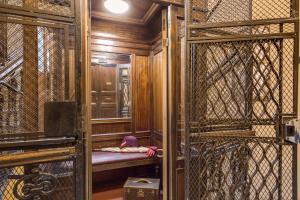 a person sitting on a bench in a room with glass doors at The Club Navona in Rome