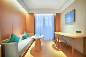 a living room with a couch and a table at JI Hotel Hangzhou West Railway Station in Hangzhou
