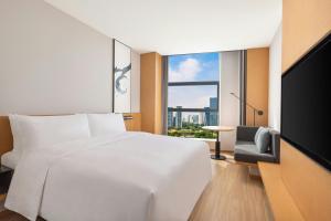 a bedroom with a white bed and a large window at Fairfield by Marriott Hangzhou Future Sci-tech City in Hangzhou