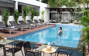 una mujer en la piscina de un hotel en The Calm Oasis, en Siem Reap