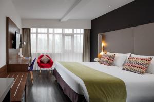a hotel room with a large bed and a red chair at Campanile Xi'an Bell Tower Huimin Street in Xi'an