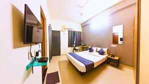 a bedroom with a bed and a flat screen tv at Inn34 By Blessings Hospitality - Porur Near DLF in Chennai