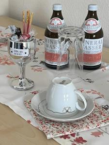 a table with a tea pot and two bottles of alcohol at Apartament in Bürstadt