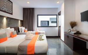 Una habitación de hotel con dos camas y un televisor. en The Calm Oasis, en Siem Reap