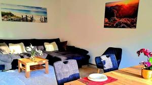 un soggiorno con un divano e un tavolo di Luxus Terrassenappartement Berg & See 2 a Tschöran