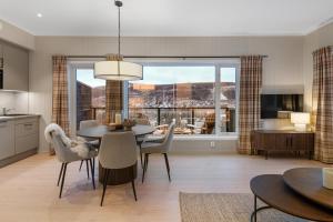 eine Küche und ein Esszimmer mit Tisch und Stühlen in der Unterkunft Motoppen Trysil Aparments in Trysil + 36 Fotos
