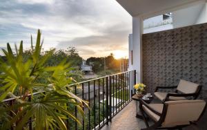 a balcony with two chairs and a table with a view at The Calm Oasis in Siem Reap