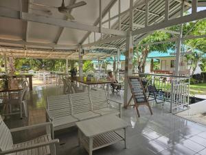 a patio with a table and chairs and people sitting at it at Kanyapa Resort กัณญภา แก่งกระจาน in Kaeng Krachan
