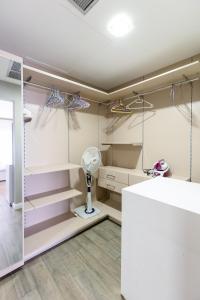 a room with white shelves and a fan at The Pearl In City by WOW Property - Direct from developer in Accra