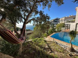 eine Hängematte vor einem Haus mit einem Pool in der Unterkunft Villa Martin AV-88 in Montjoys