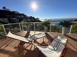 2 Stühle auf einem Balkon mit Meerblick in der Unterkunft Villa Martin AV-88 in Montjoys