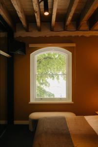 a window in the corner of a room with a table at Gibson Mill waterfront warehouse apartment - 101 in Hobart