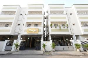 a white building with plants in front of it at Inn34 By Blessings Hospitality - Porur Near DLF in Chennai