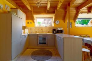 una cucina con pareti gialle e soffitti in legno di SV2 Knechtsand 16 a Dorum-Neufeld