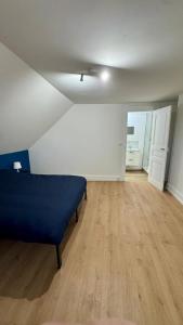 - une chambre avec un lit bleu et du parquet dans l'établissement Cosy 6 - Belfort centre, à Belfort