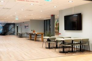 Una sala de conferencias con mesas, sillas y televisión. en Scandic Stavanger Forus, en Stavanger