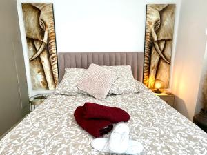 Horizon village des Pennes Mirabeau في لي-بين-ميرابو: سرير عليه منشفة حمراء وحذاء