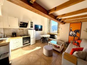 Horizon village des Pennes Mirabeau في لي-بين-ميرابو: مطبخ وغرفة معيشة مع أريكة وطاولة