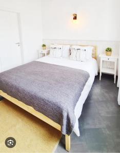 ein großes Bett in einem Zimmer mit 2 Tischen in der Unterkunft Home Place Cascais Estoril in Cascais