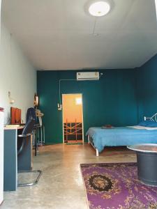a room with a bed and a green wall at Six Nature Resort in Chiang Rai