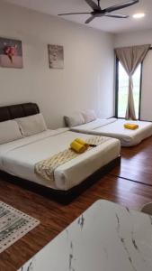una camera da letto con due letti e un ventilatore a soffitto di Hayyan Homestay a Kampong Tangihan