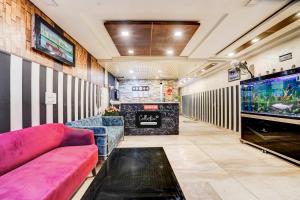 Collection O Kalka Ji Formerly Hotel Gera في نيودلهي: غرفة معيشة مع أريكة وحوض أسماك