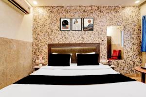 a bedroom with a large white bed and some wallpaper at Collection O Kalka Ji Formerly Hotel Gera in New Delhi