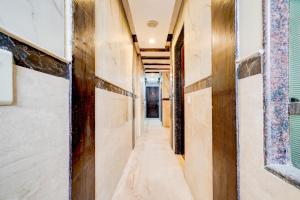 Collection O Kalka Ji Formerly Hotel Gera في نيودلهي: ممر في منزل به جدران خشبية وممر