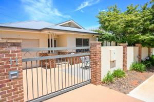 a house with a wrought iron fence with a patio at Griffith Prestige Apartment in Griffith