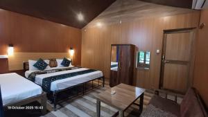 Sai Palolem Beach cottages في بالوليم: غرفة فندق بها سريران وطاولة