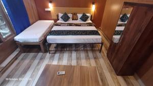 Sai Palolem Beach cottages في بالوليم: غرفة صغيرة بسريرين ودرج +صورتان