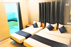 a hotel room with two beds and a window at Inn34 By Blessings Hospitality - Porur Near DLF in Chennai +36 photos