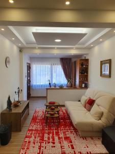 een woonkamer met een witte bank en een rood kleed bij Luxury Family Villa on Neretva - Private Pool - Vila Kuća Mira in Konjic