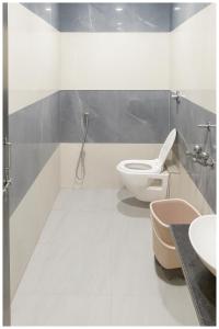 a white bathroom with a toilet and a sink at Hotel Premium IN Tulsi GH Near Shri Mahakaleshwar Jyotirlinga Temple - Fully Air Air Conditioning Rooms - Prime Location in Ujjain